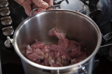 Rosolare la carne da bollito a dadini.